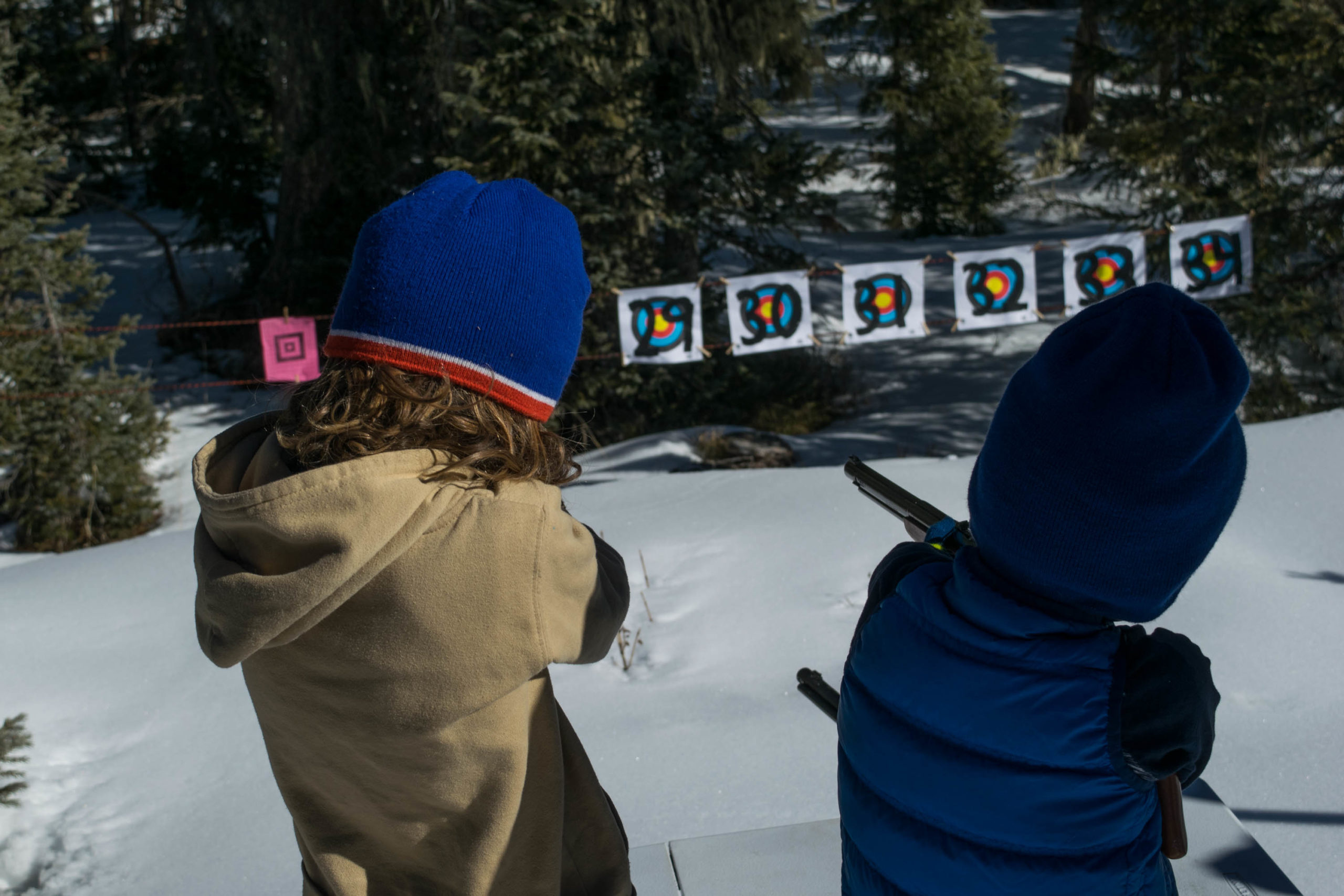 Kids shooting bb guns while skiing