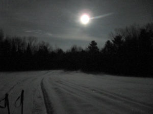 Moon rising over groomed ski lanes